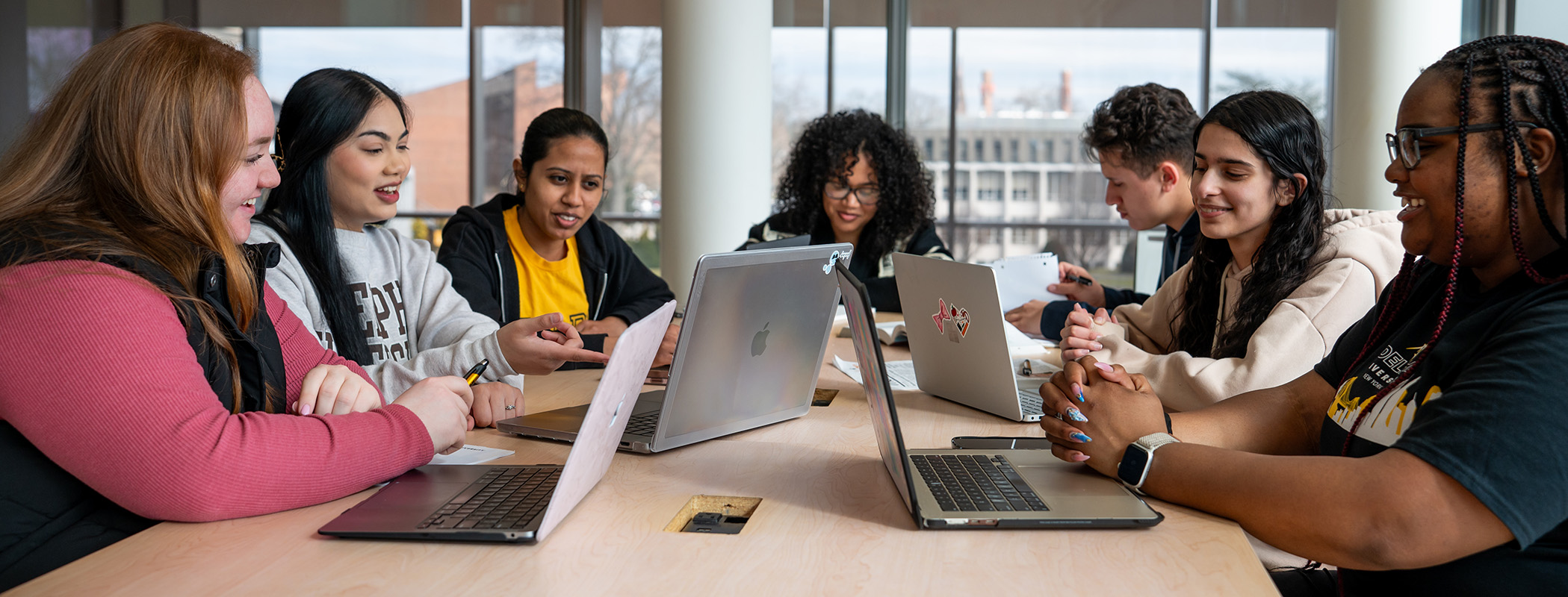 A diverse grop of Adelphi students study in Nexus Building.